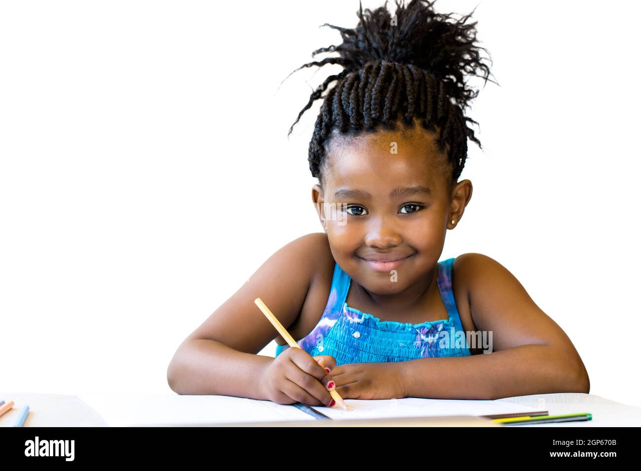Nahaufnahme Porträt von kleinen afrikanischen Mädchen mit Farbstift am Schreibtisch.isoliert auf weißem Hintergrund. Stockfoto