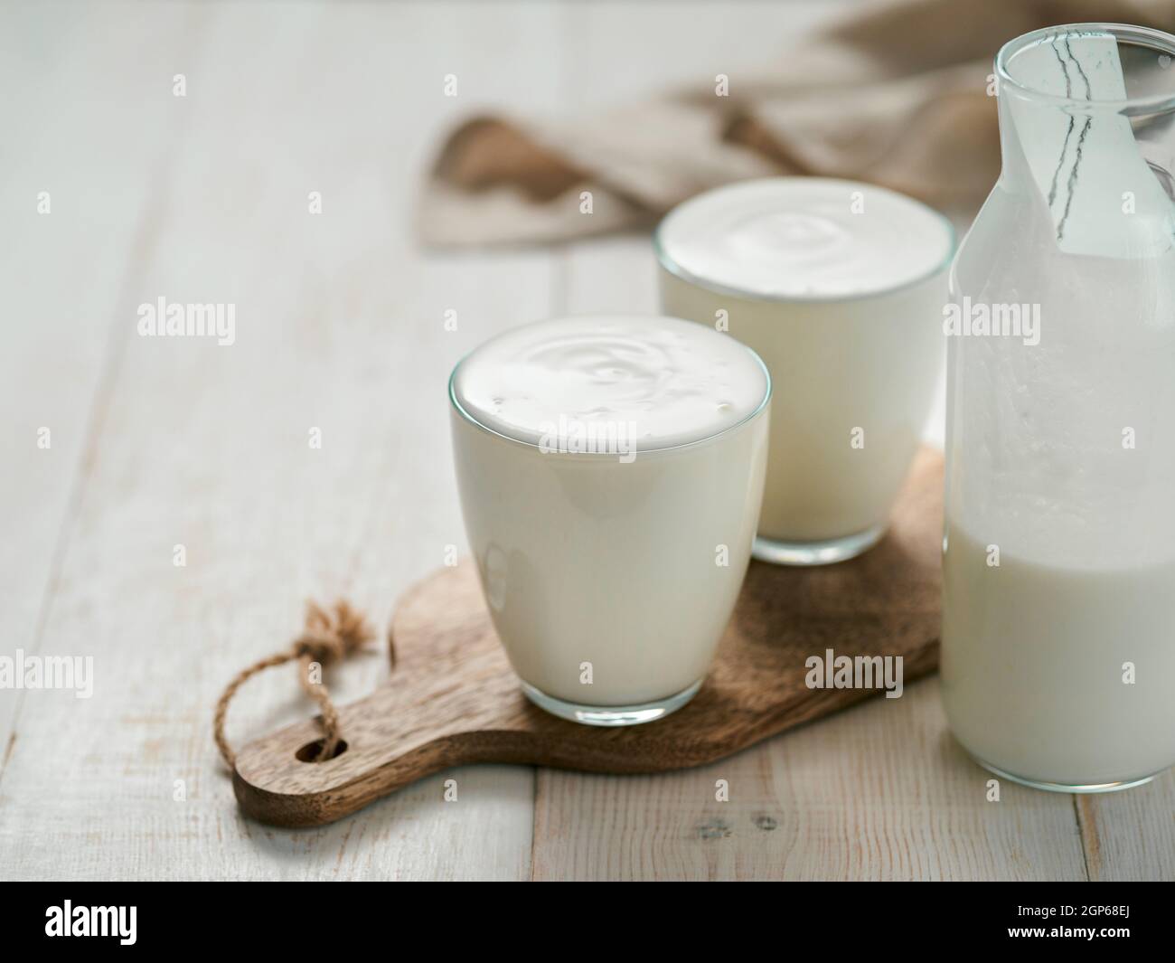Kefir, Buttermilch oder Joghurt mit Probiotika. Joghurt im Glas auf weißem Holzhintergrund