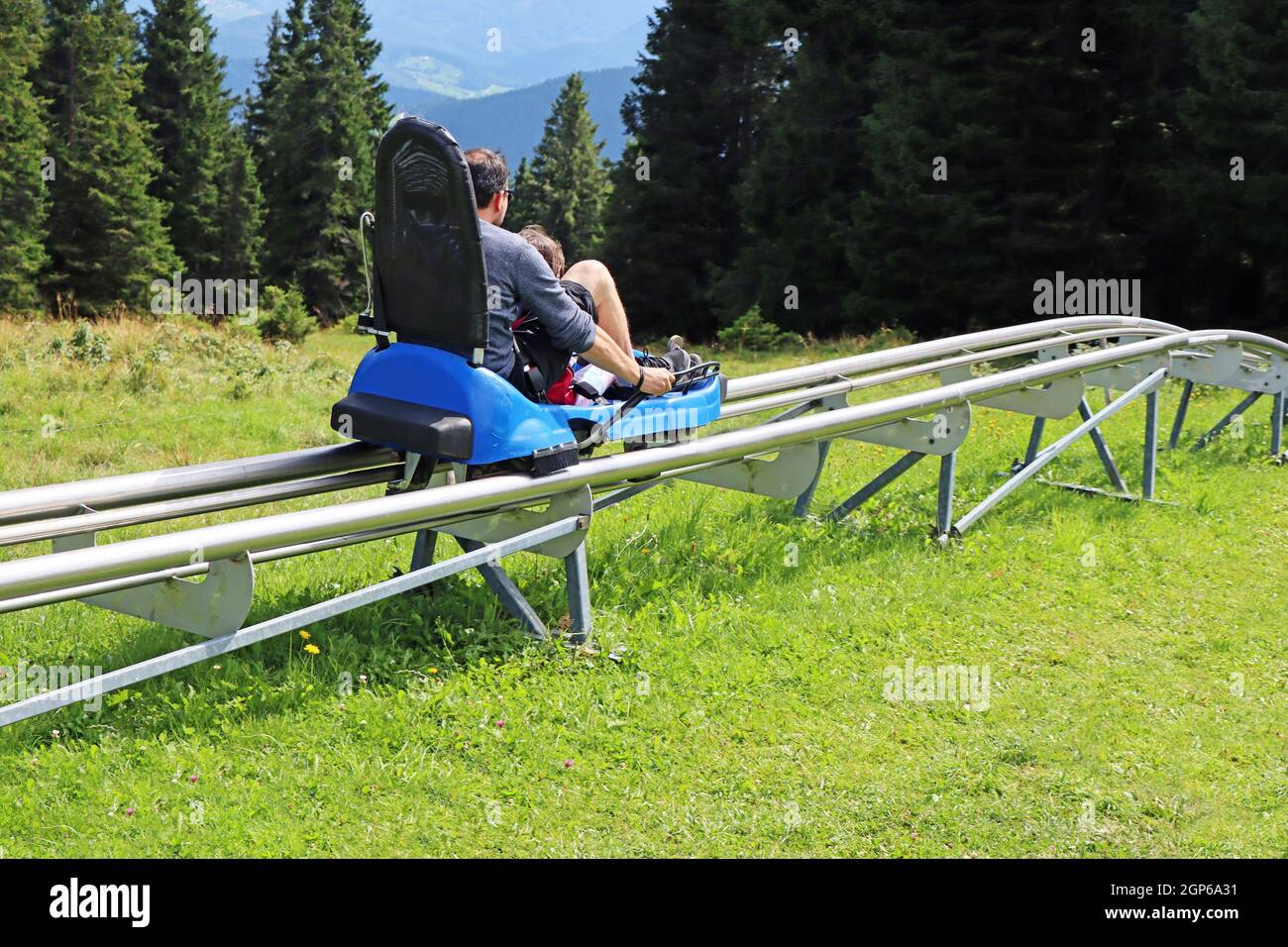 Vater und Sohn genießen eine sommerliche Achterbahnfahrt in Rogla, Slowenien Stockfoto