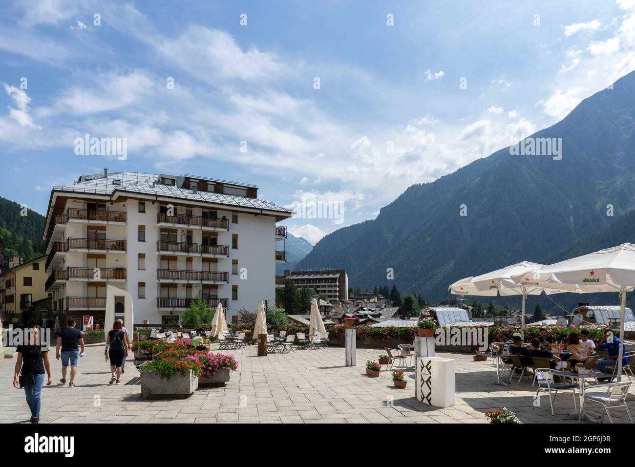 Courmayeur, Italien - August 24 2021: Restaurant oder Café mit Außenbereich in Norditalien. Sonnenschirme, Sonnenschirme mit Tisch und Stühlen und Berg Stockfoto