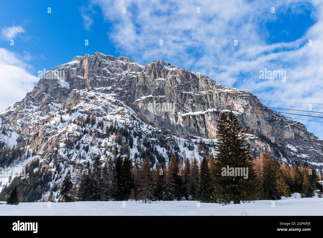 Schneebedeckter felsiger Gipfel in den Europäischen Alpen an einem klaren Wintertag. Auf dem Gipfel des Berges ist eine Seilbahnstation zu sehen. Stockfoto