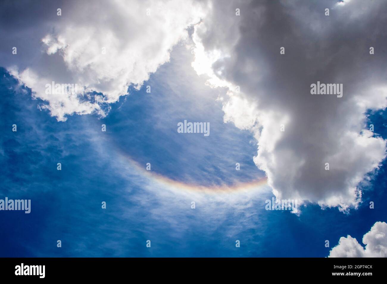 SANTA CLARA, KUBA- 22. MAI 2011:Regenbogen am Himmel zwischen zwei Wolken, gebildet in der Mitte des Himmels, um 12:01 Uhr Stockfoto