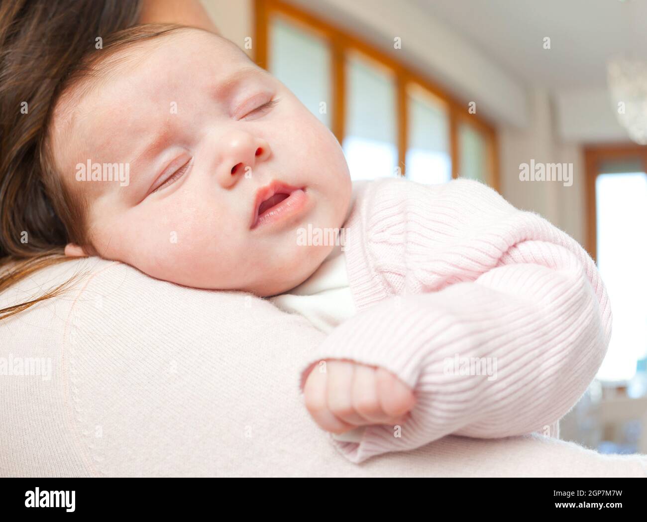 Porträt eines niedlichen neugeborenen Mädchens auf ihre Mutter Schulter zu Hause schlafen Stockfoto