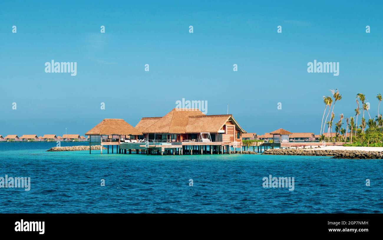 Luxuriöse Resort auf einer Insel auf den Malediven. Typische Residences mit Strohdächern für einen Traumurlaub. Stockfoto