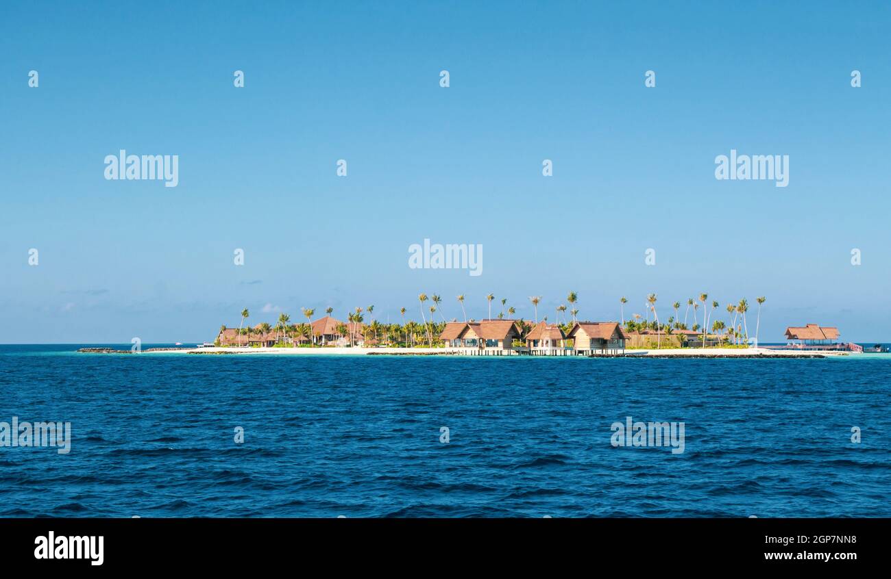 Luxuriöse Resort auf einer Insel auf den Malediven. Typische Residences mit Strohdächern für einen Traumurlaub. Stockfoto