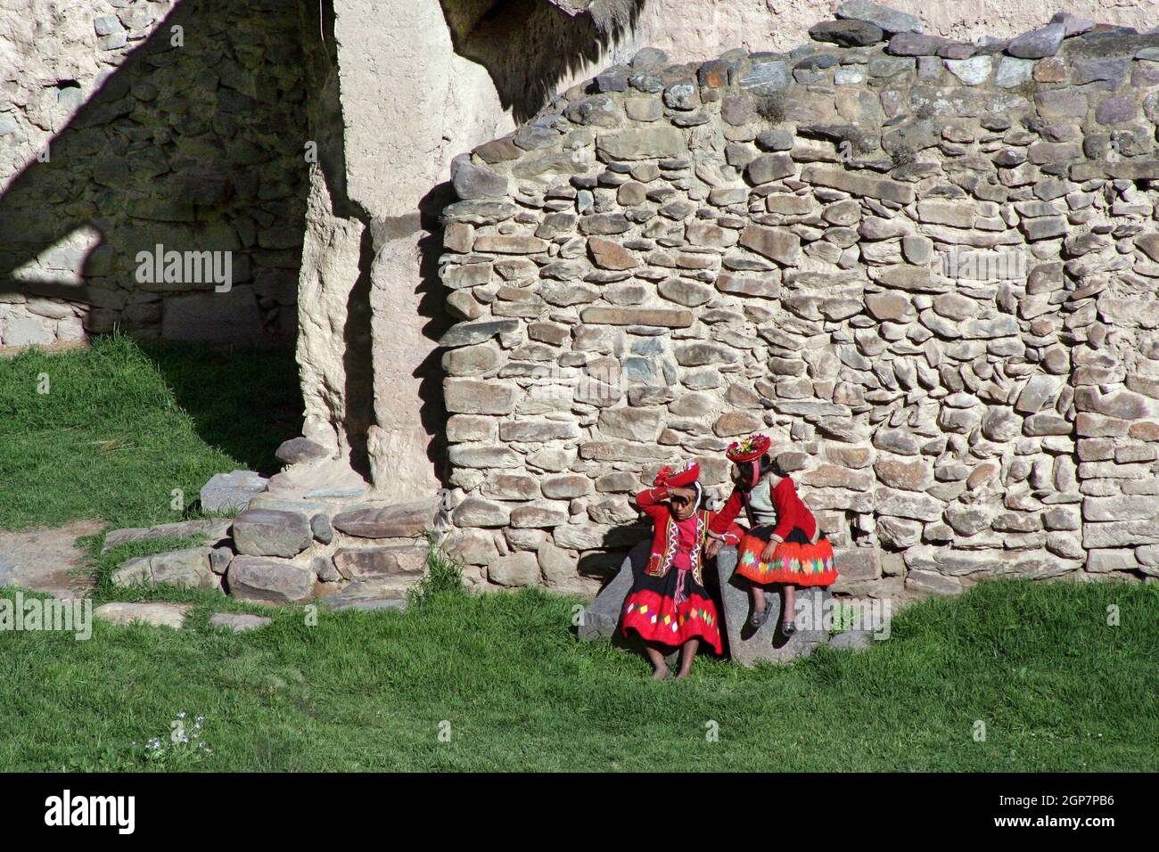 Zwei einheimische Mädchen in traditioneller Kleidung in den inkanischen Ruinen von Ollantaytambo im Heiligen Tal, Peru Stockfoto