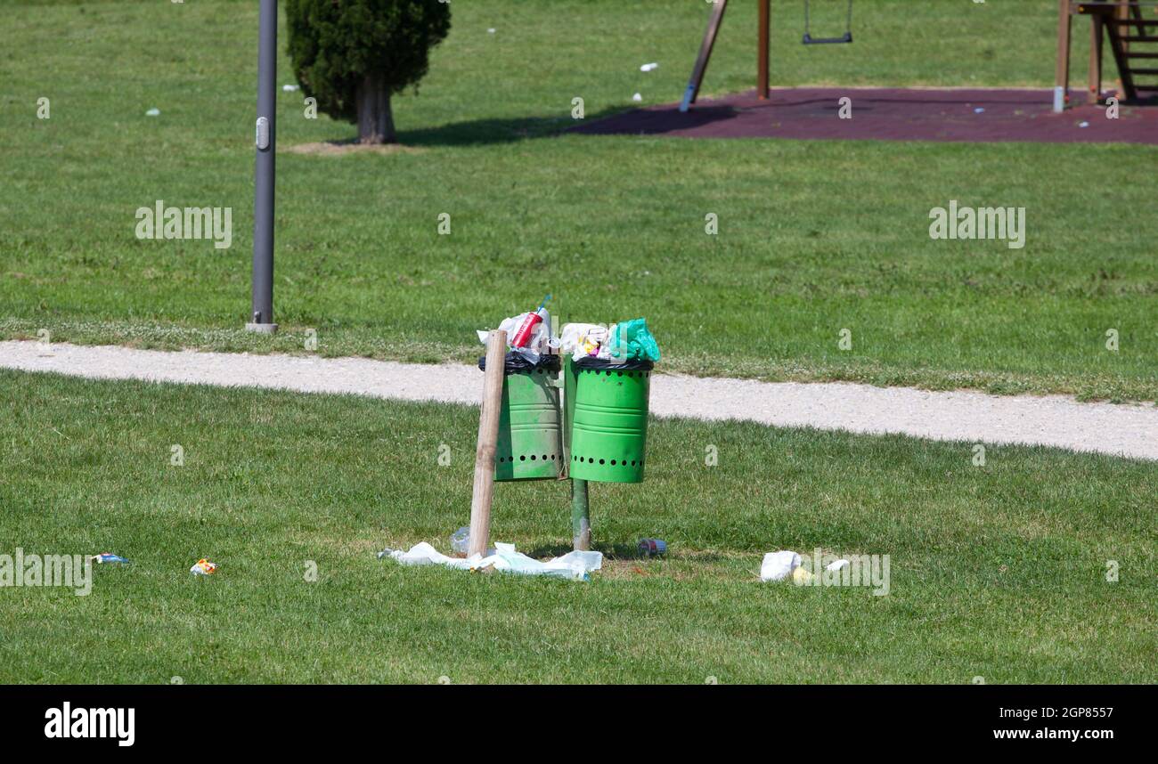 Papierkorb voller Abfälle auf den Boden in einem Outdoor-Park. Stockfoto