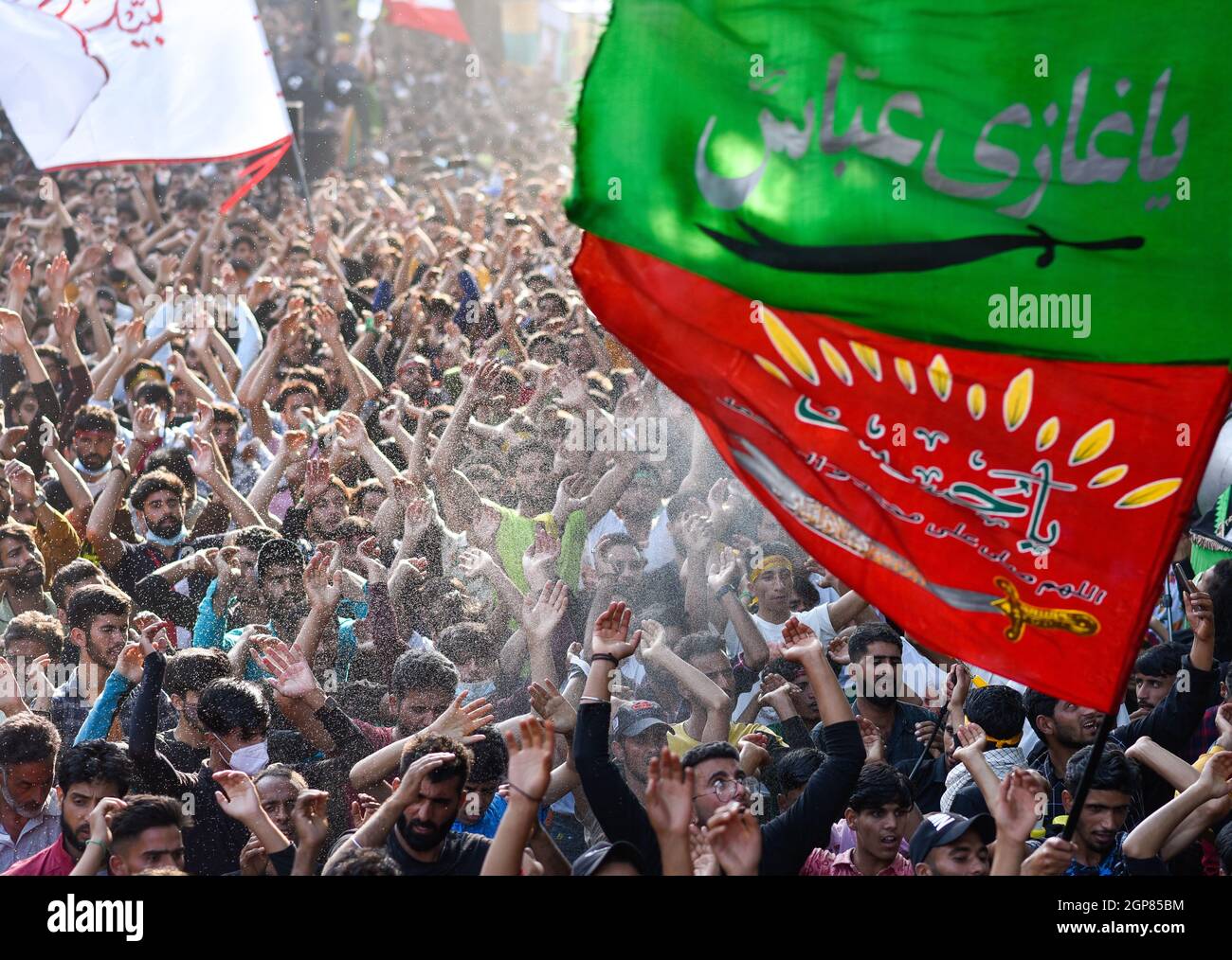 Srinagar, Indien. September 2021. Schiitische Muslime schwenken religiöse Fahnen und heben ihre Hände während einer religiösen Prozession, um Arbaeen in Srinagar zu markieren. Arbaeen ist der 40. Tag nach Ashura, der an die Tötung des Enkels Imam Hussain und seiner 72 Gefährten aus dem siebten Jahrhundert des Propheten Mohammed erinnert. Kredit: SOPA Images Limited/Alamy Live Nachrichten Stockfoto