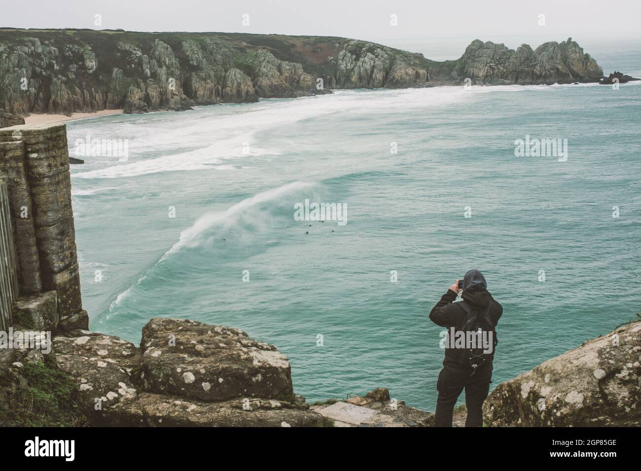 Wasserlandschaft in Cornwall England Mann auf der Klippe fotografiert Stockfoto