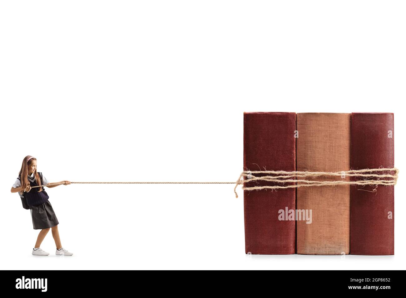 In voller Länge Profilaufnahme eines Schulmädchen, das mit einem Seil auf weißem Hintergrund große Bücher zieht Stockfoto