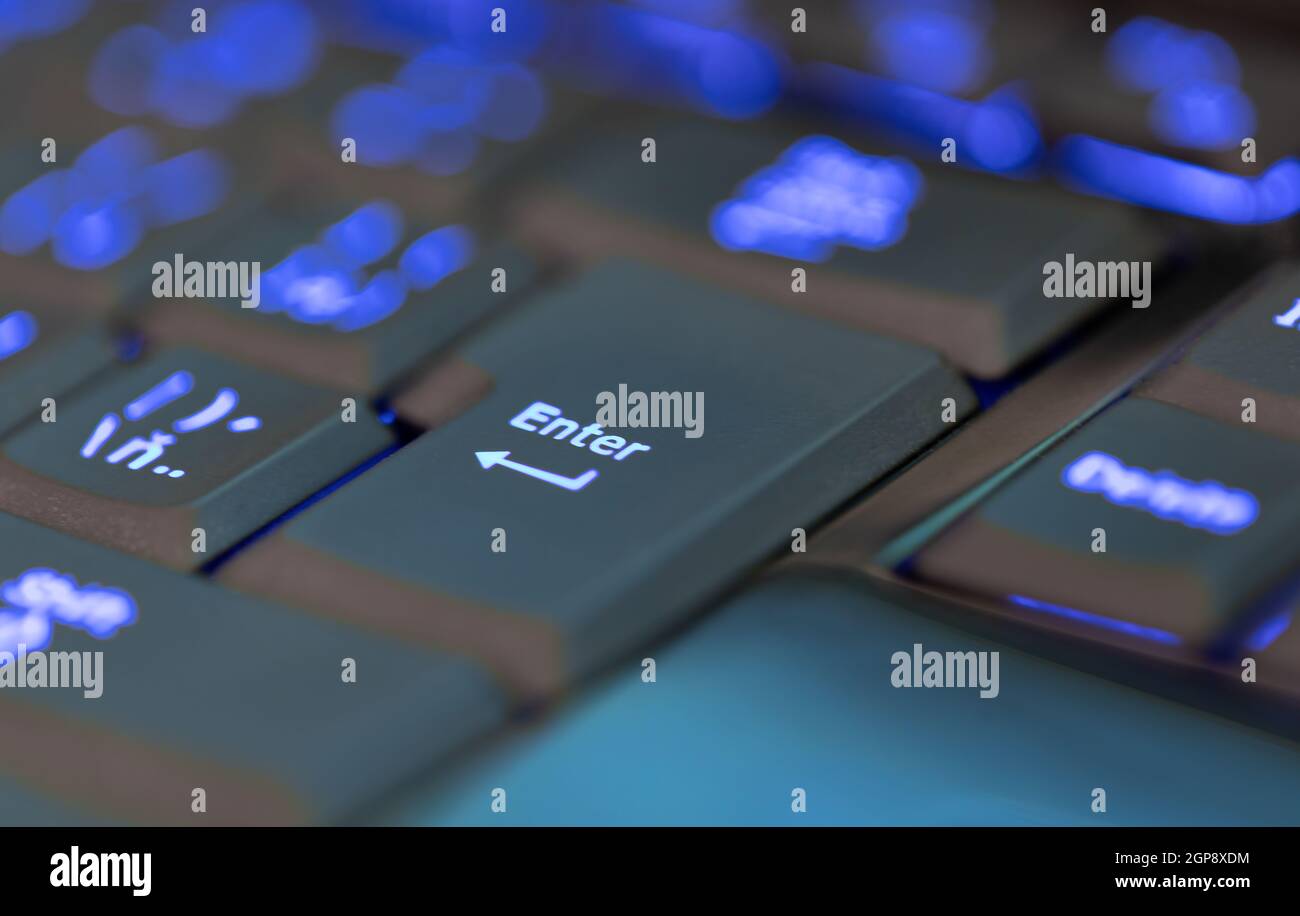 Nahaufnahme der Tastaturbeleuchtung für Laptop oder Desktop-Computer,  Tastatur mit blauer Hintergrundbeleuchtung. Fokus, um die Eingabetaste zu  drücken Stockfotografie - Alamy