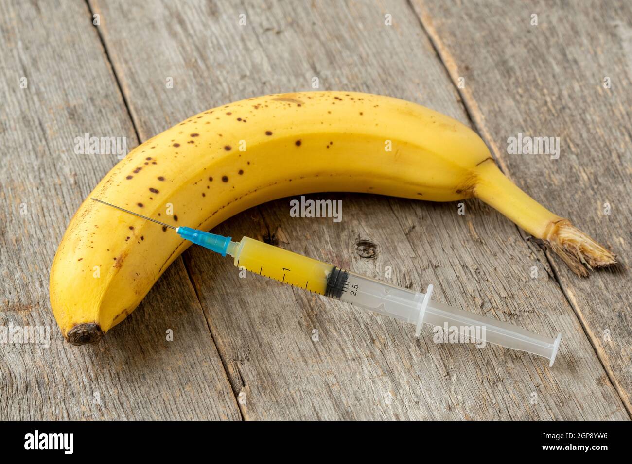 Spritze und Banane. Konzept für genetisch veränderte Lebensmittel und kosmetische Medizin Stockfoto