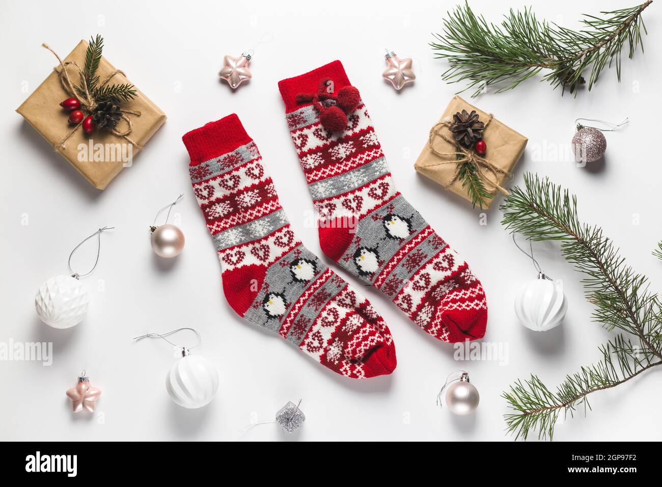 Gemütliche Winterweihnachtsstimmung. Flaches Lay aus warmen Kätzchen-Socken, Tannenzweigen und Geschenkboxen. Draufsicht Stockfoto