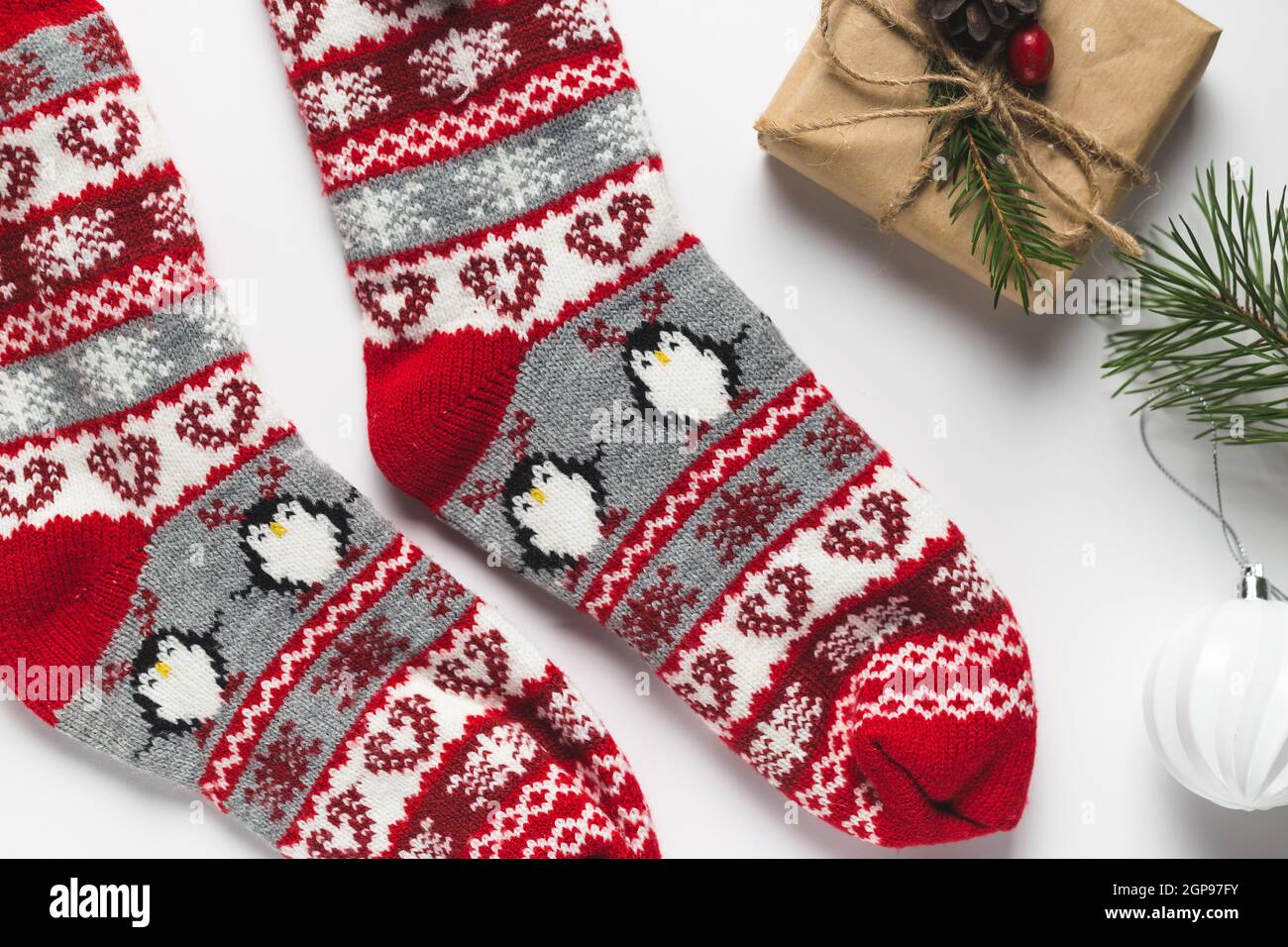 Gemütliche Winterweihnachtsstimmung. Flaches Lay aus warmen Kätzchen-Socken, Tannenzweigen und Geschenkboxen. Draufsicht Stockfoto