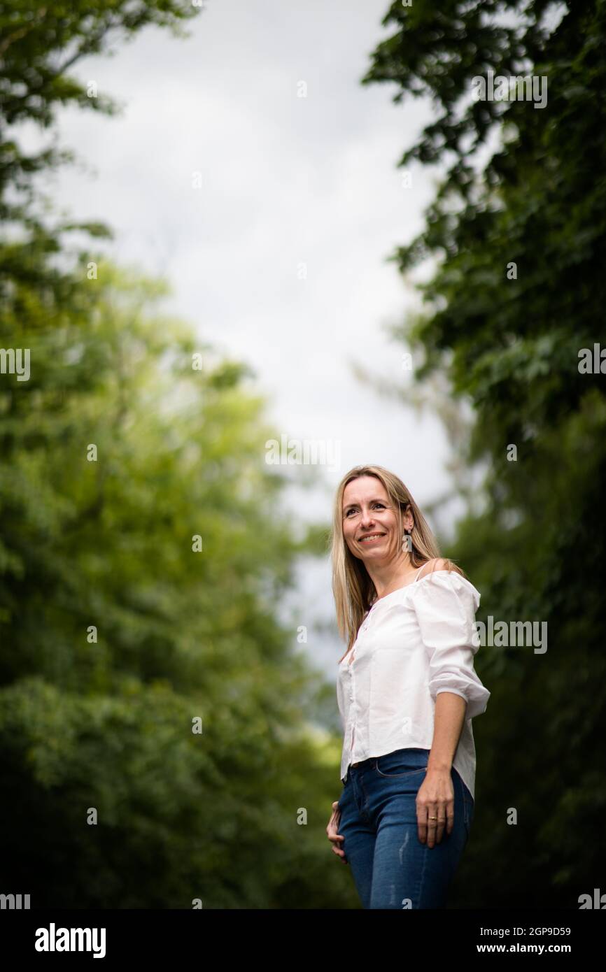 Porträt einer entspannten Frau mittleren Alters im Freien, glücklich aussehen, genießen das Leben Stockfoto