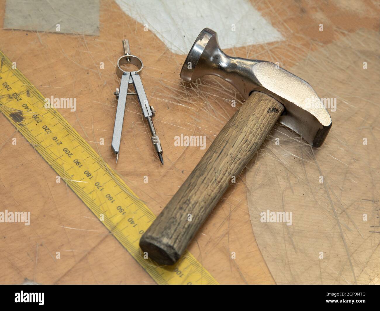 Schuhmacher Werkzeuge, Kreis und ein Maßband auf einem Schreibtisch. Symbolisch für Handwerker und ihren Arbeitsplatz. Stockfoto