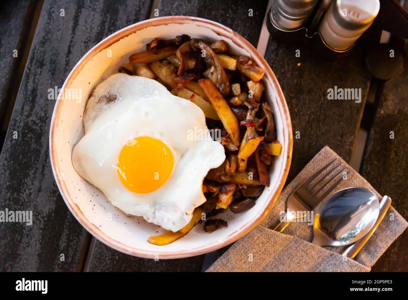 Spiegeleier serviert mit gebratenen Kartoffeln mit Pilzen Stockfoto