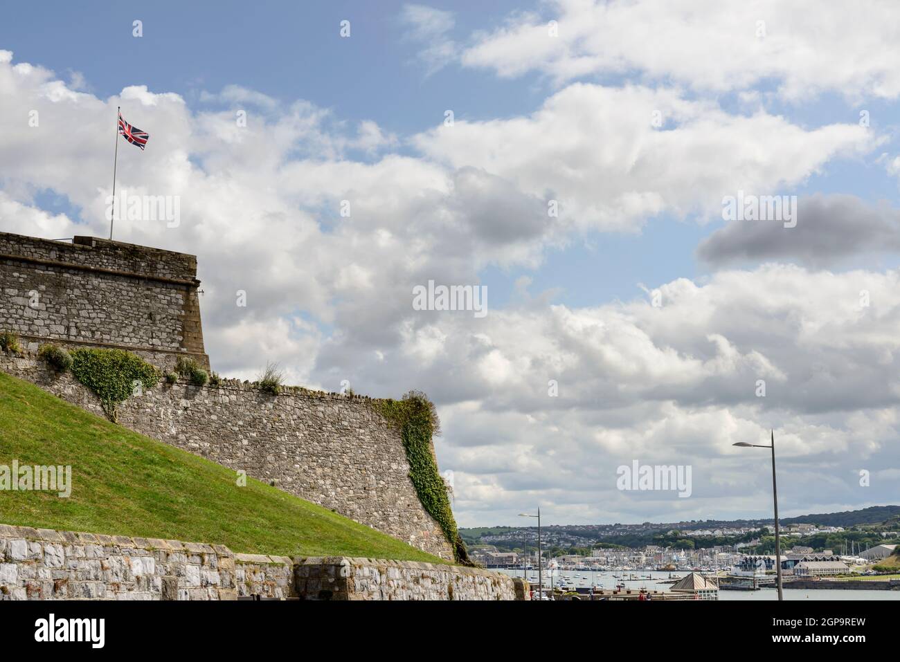 Blick auf die riesige Mauer, die den Bereich der Burg und Stadtbild der historischen Küstenstadt Devon unter einem hellen bewölkten Himmel umschließt Stockfoto