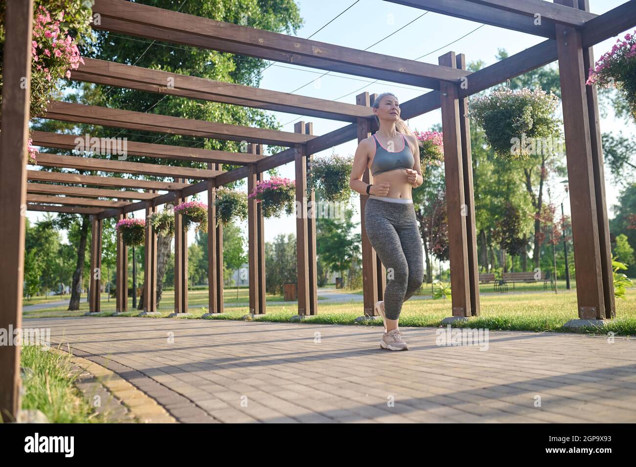 Eine langhaarige Womna im Sportkleidung Joggen im Park Stockfoto