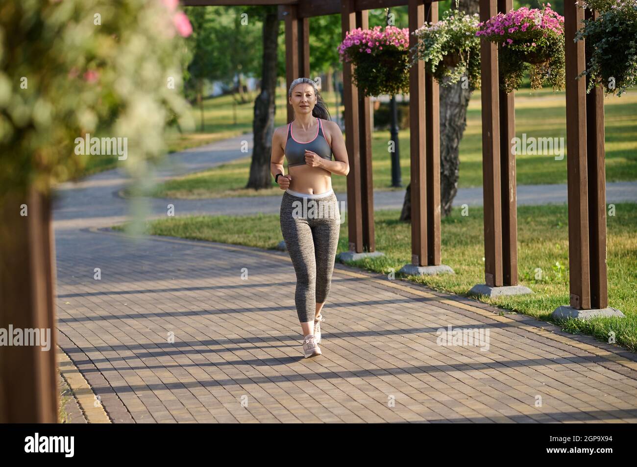 Eine langhaarige Womna im Sportkleidung Joggen im Park Stockfoto