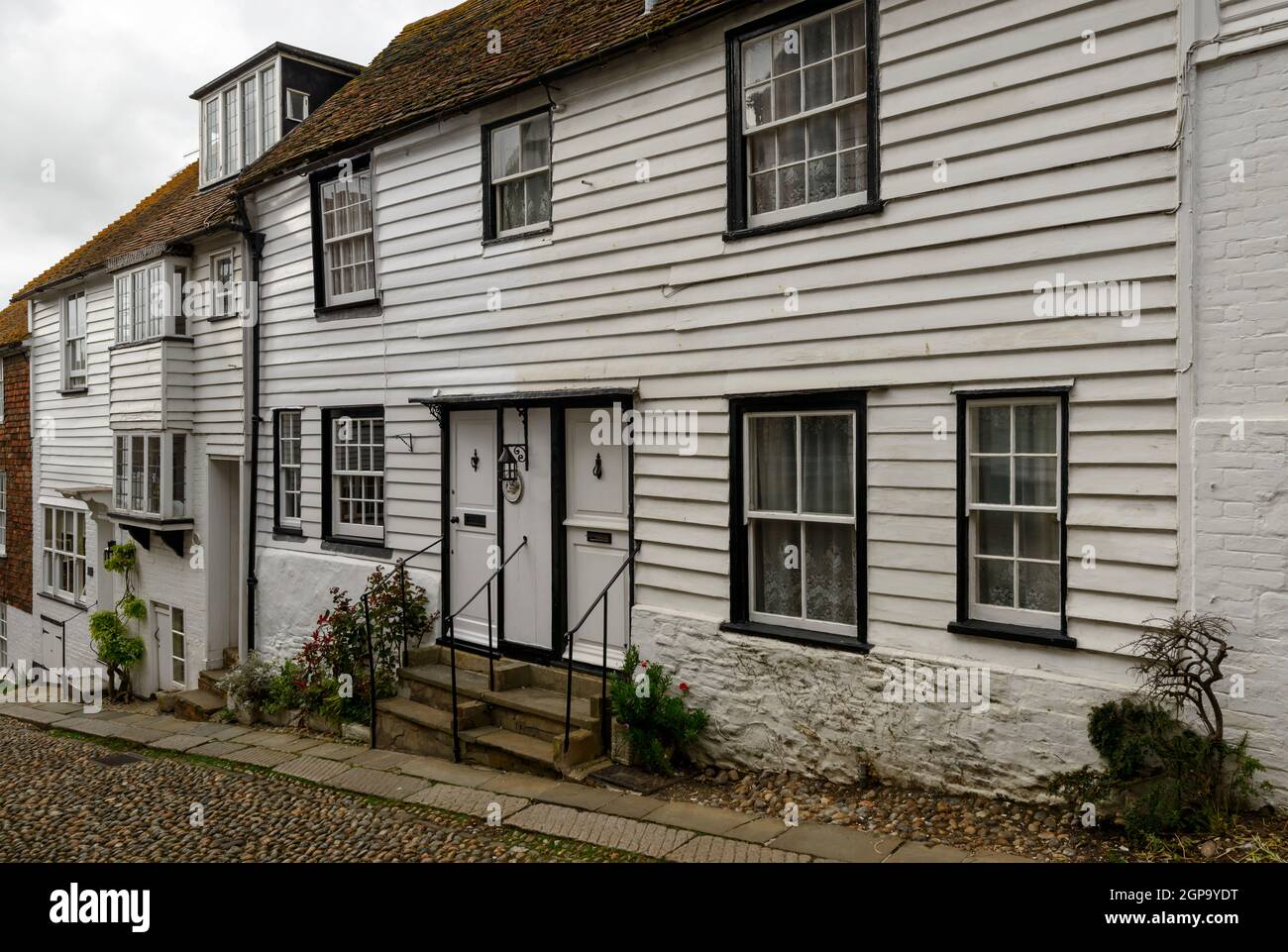 Blick auf alte Häuser in einer bergauf führenden Straße im historischen Dorf Rye, East Sussex Stockfoto