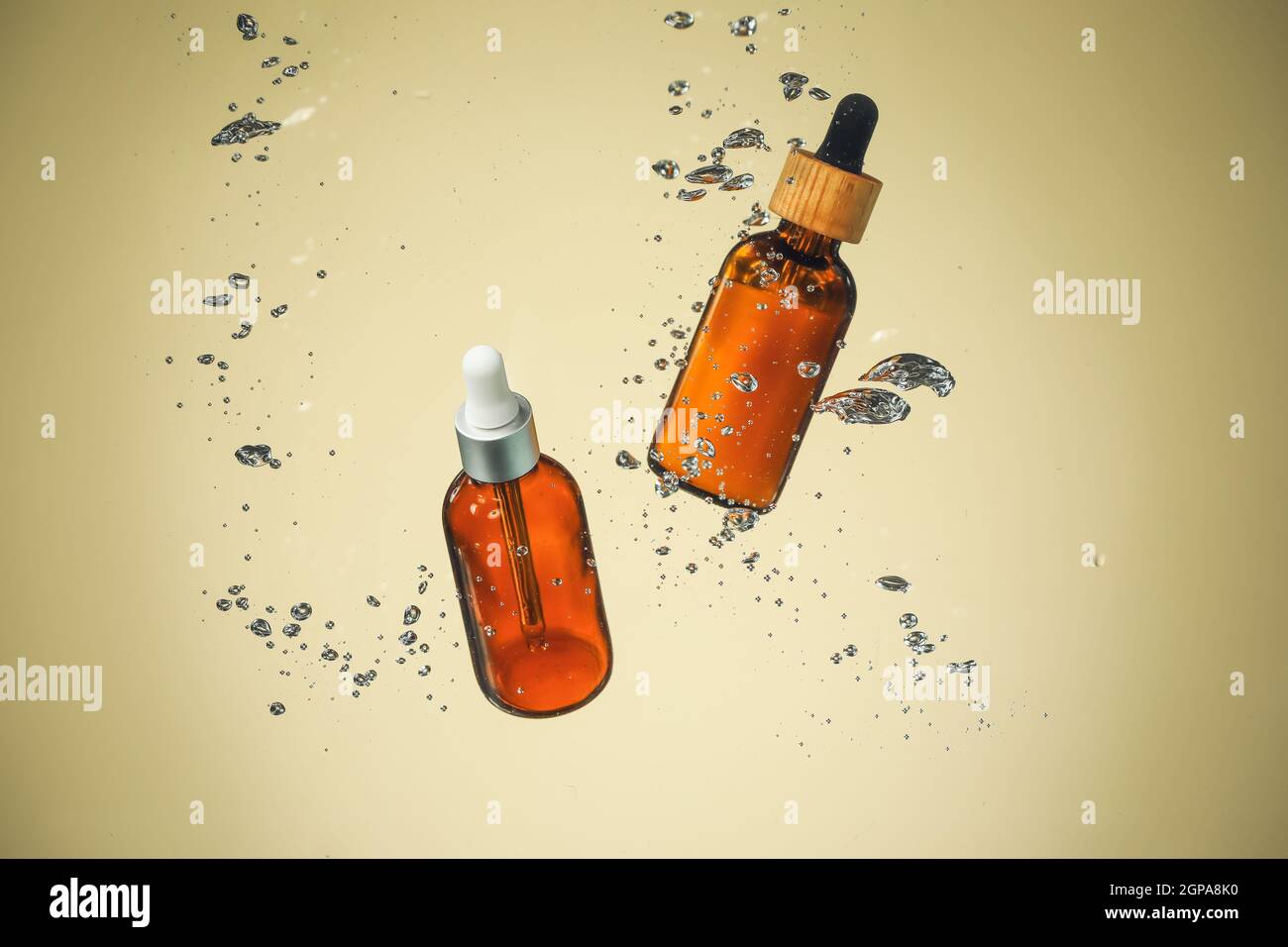 Flaschen ätherisches Öl in Wasser auf farbigem Hintergrund Stockfoto