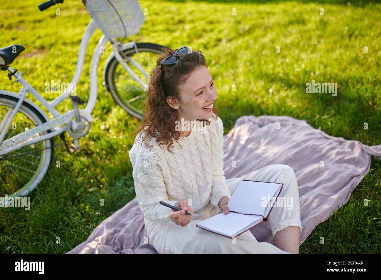 Ein junges Mädchen mit einem Tagebuch in den Händen, das denkt und Notizen macht Stockfoto
