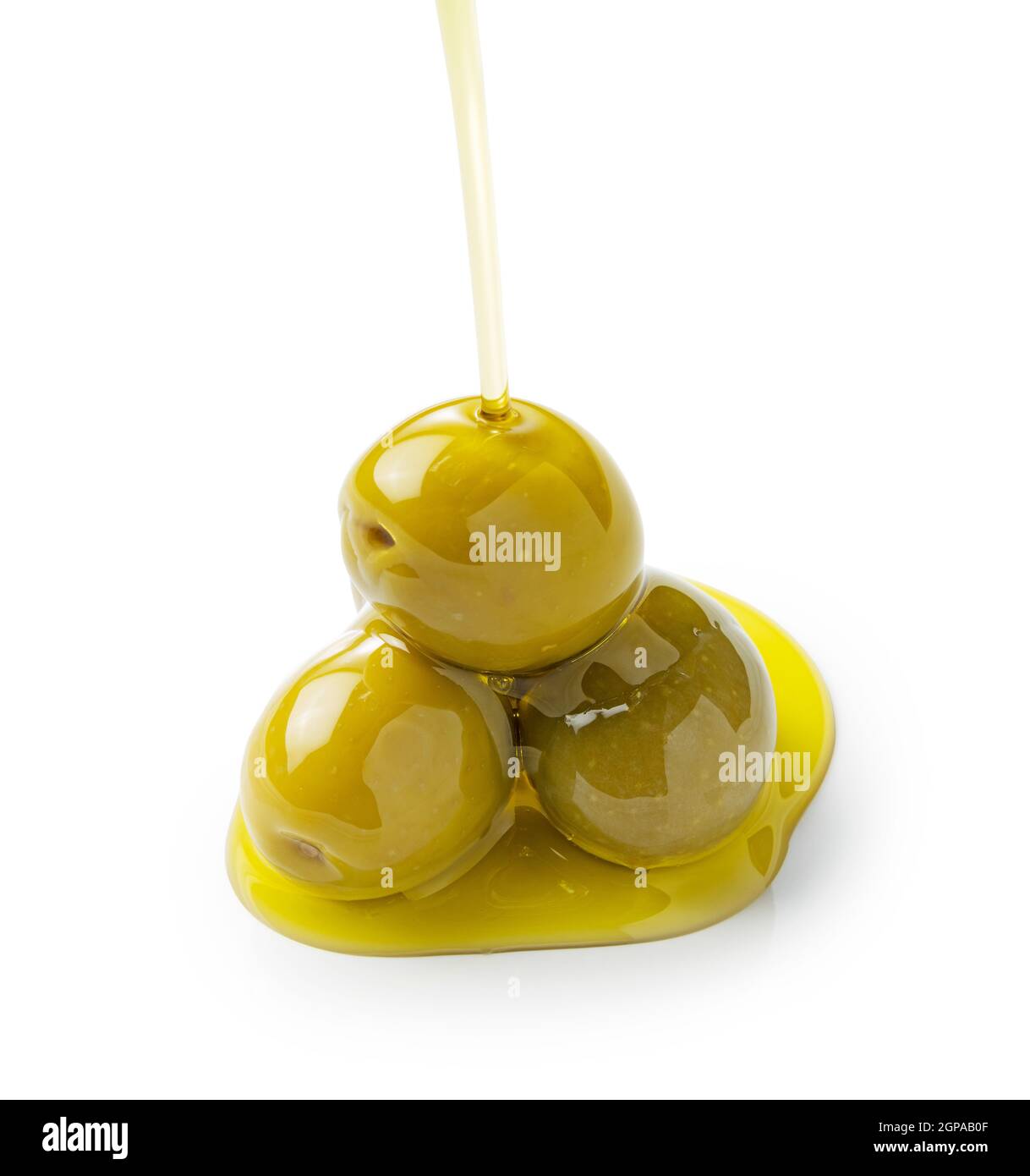 Der Moment, in dem Olivenöl über Oliven gegossen wird, die auf weißem Hintergrund stehen Stockfoto