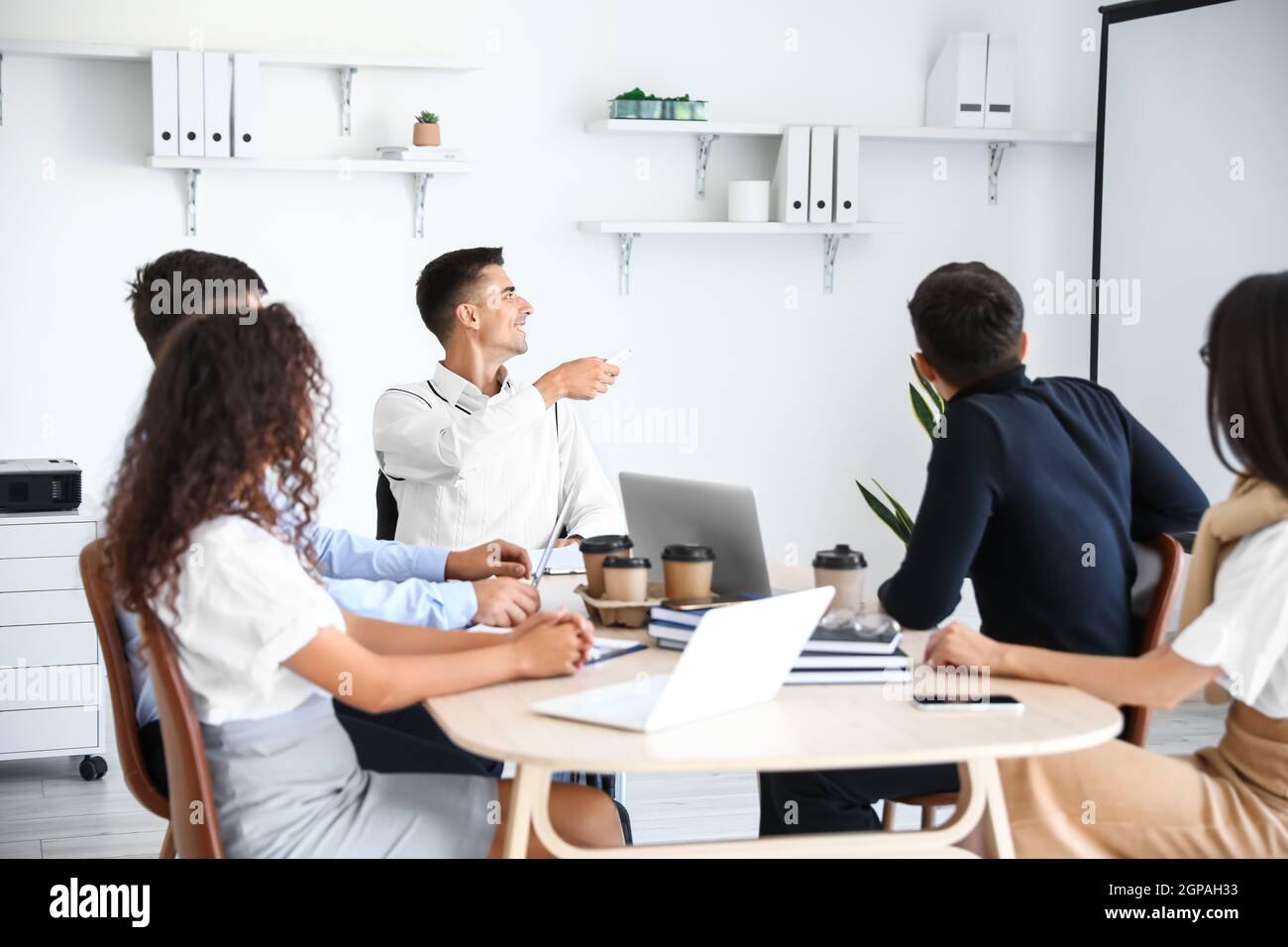 Mann im Rollstuhl, der im Büro vorgeführt wird Stockfoto