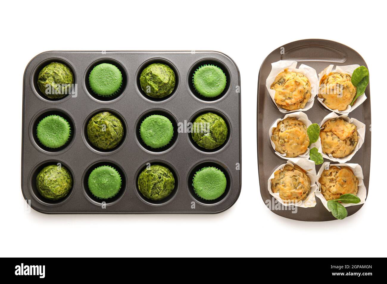 Backformen mit leckeren Spinat-Muffins auf weißem Hintergrund Stockfoto