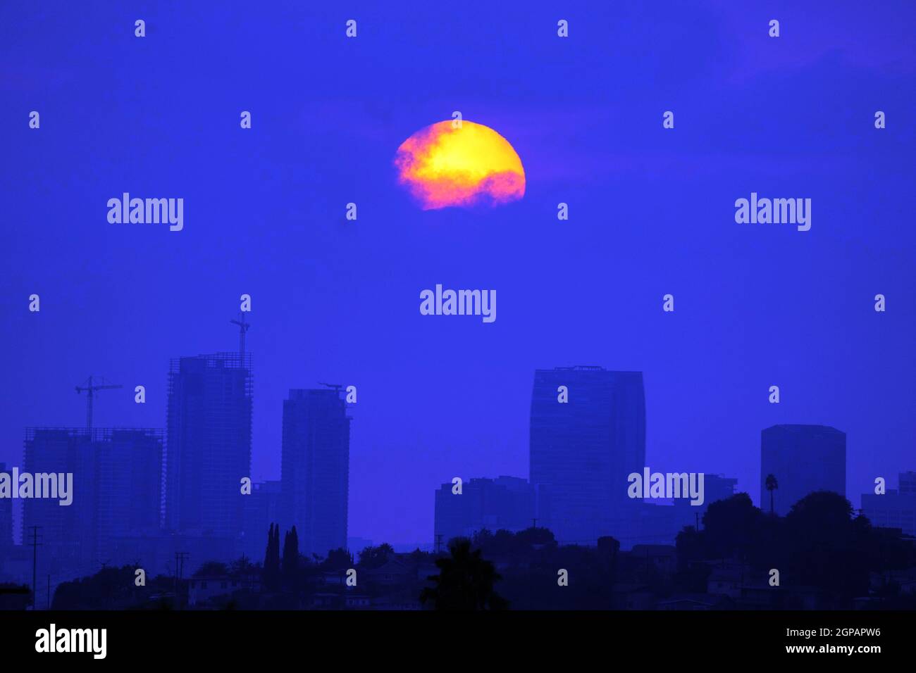 Am Dienstag, den 28. September 2021, in Los Angeles untergeht die Sonne über der Skyline der Innenstadt in einem durch Waldbrände verdunkelten Himmel. Stockfoto