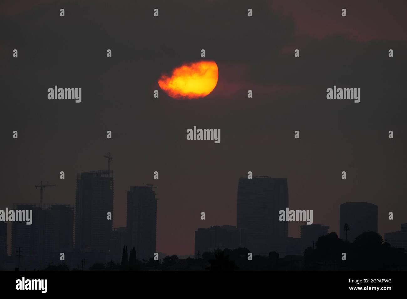 Am Dienstag, den 28. September 2021, in Los Angeles untergeht die Sonne über der Skyline der Innenstadt in einem durch Waldbrände verdunkelten Himmel. Stockfoto
