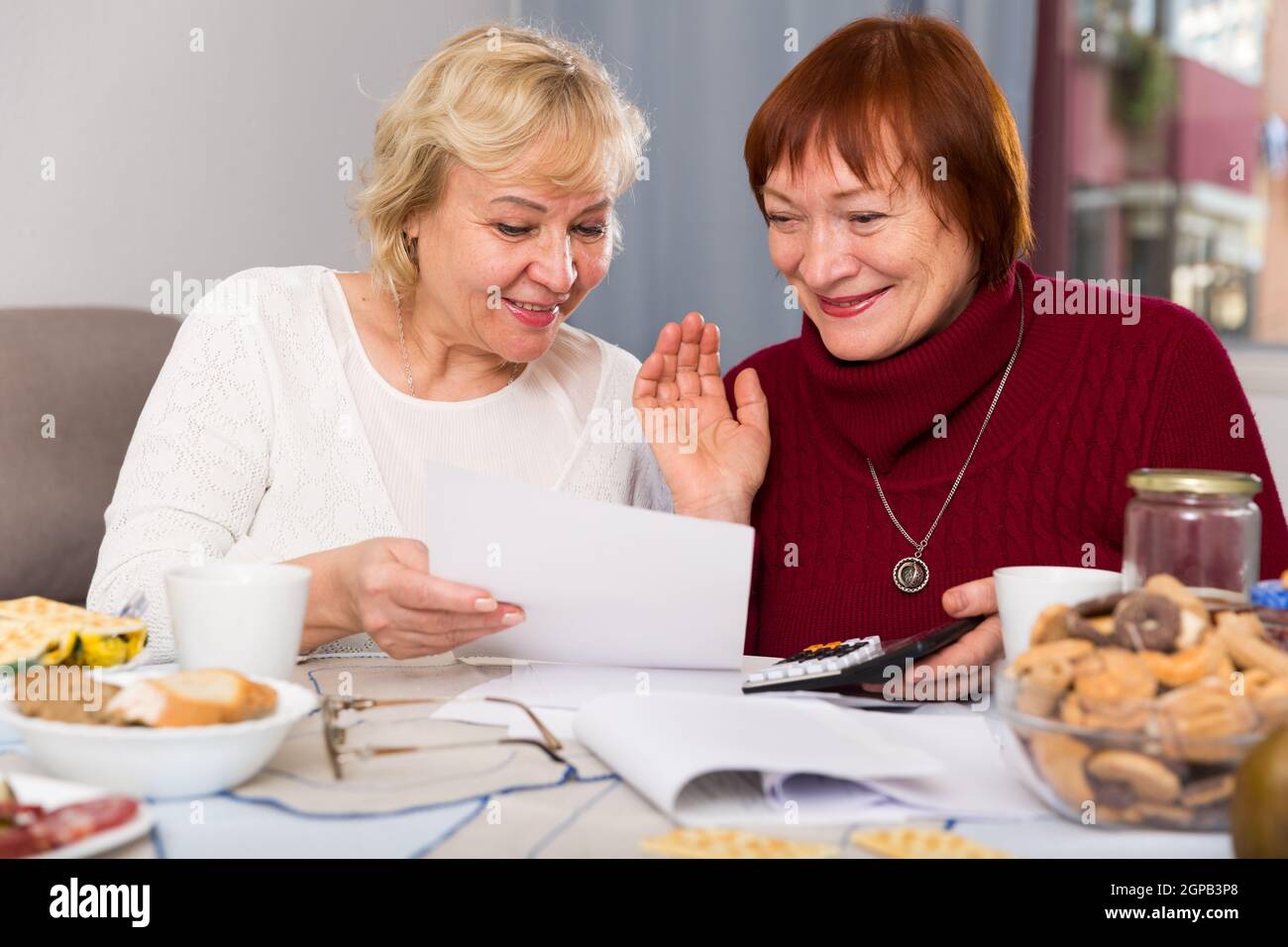 Zwei positive reife Frauen mit Papieren Stockfoto
