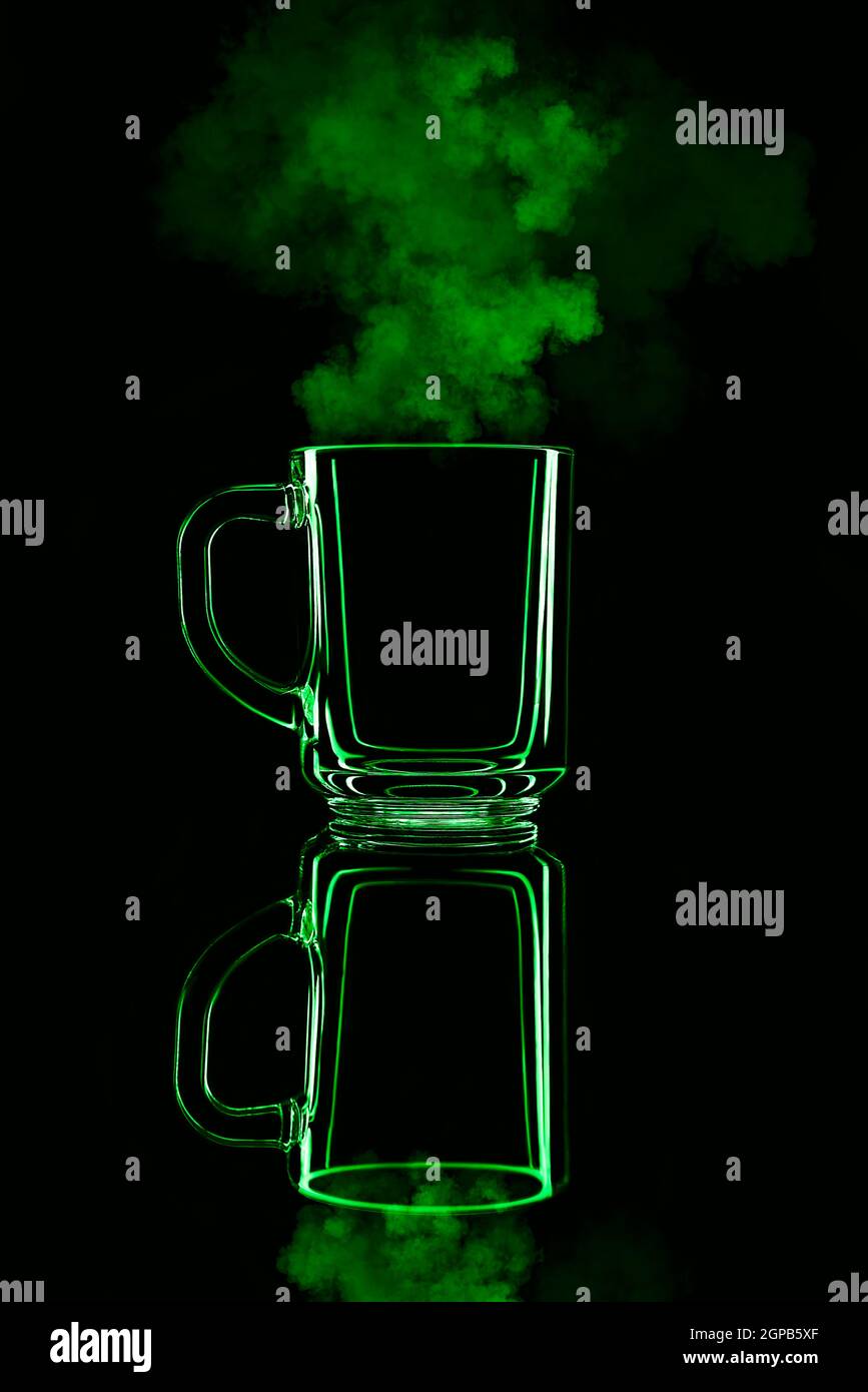 Nur ein Glas auf schwarzem Hintergrund mit einer Spiegelung. Grüne Farbe, mit Dampf. Isoliert. Stockfoto