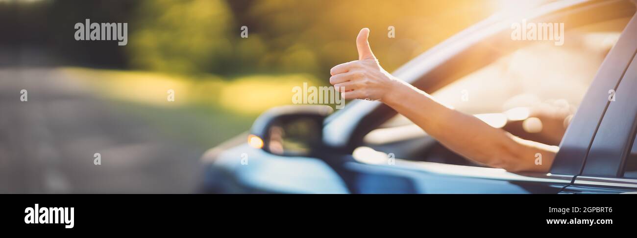 Frau in ihrem Auto gestikulieren den Daumen nach oben. Konzept des Autokaufens und positive Emotionen. Stockfoto