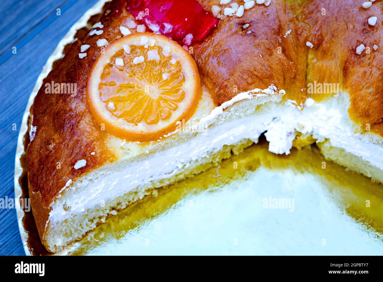 Weihnachtliche runde Obstkuchen mit Tannenzweigen, glasierten Früchten und Nüssen auf einem hölzernen Hintergrund. Stockfoto