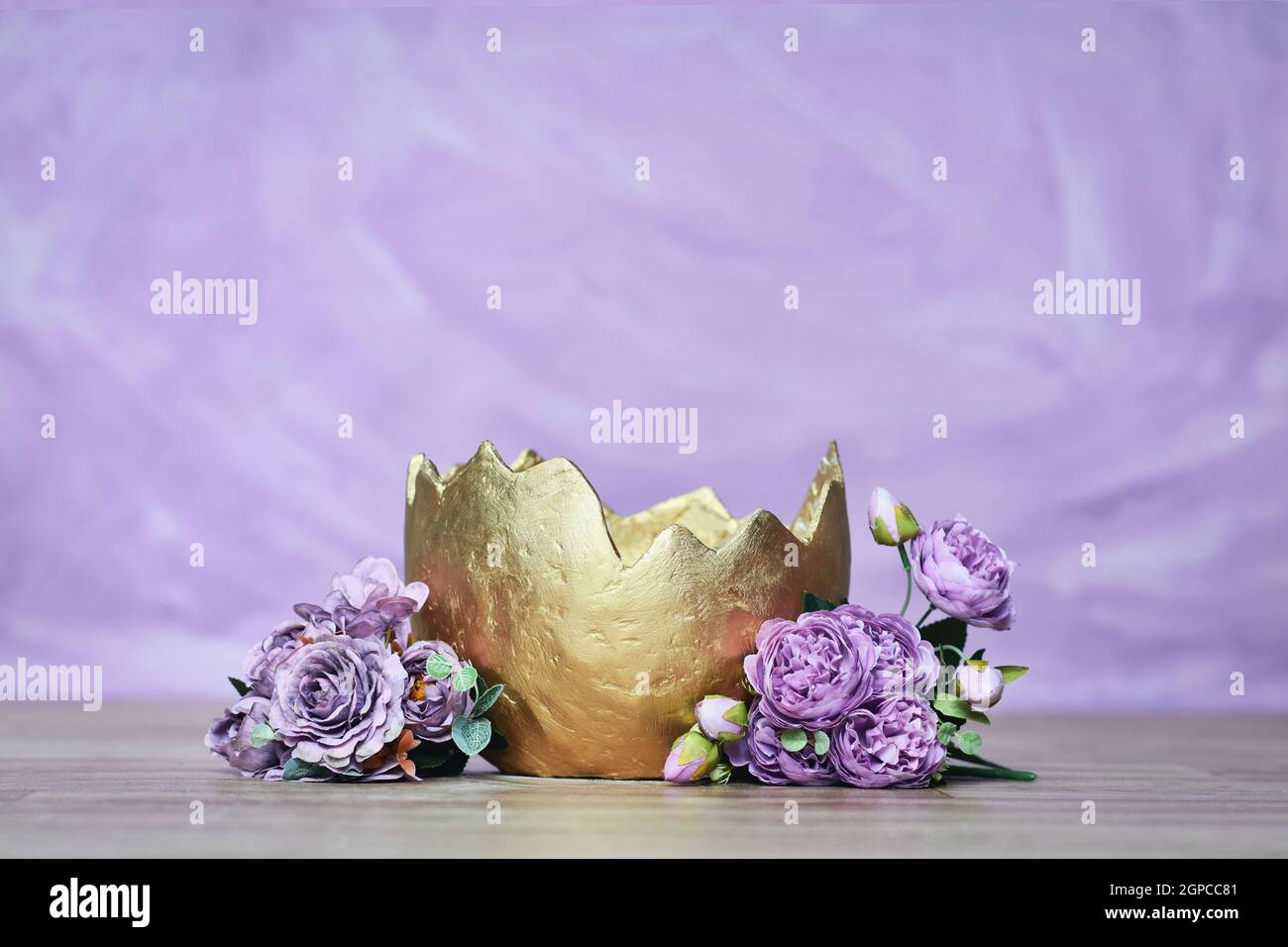 Neugeborener digitaler Hintergrund mit goldenem Ei mit Blumen auf violettem Hintergrund Stockfoto