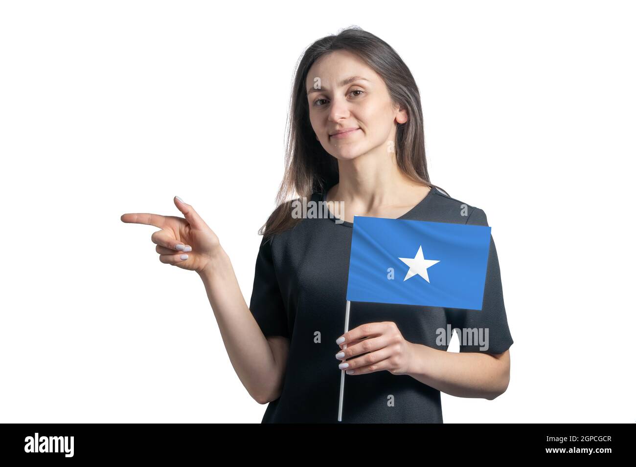 Glückliche junge weiße Frau hält Flagge Somalia und zeigt nach links isoliert auf einem weißen Hintergrund. Stockfoto