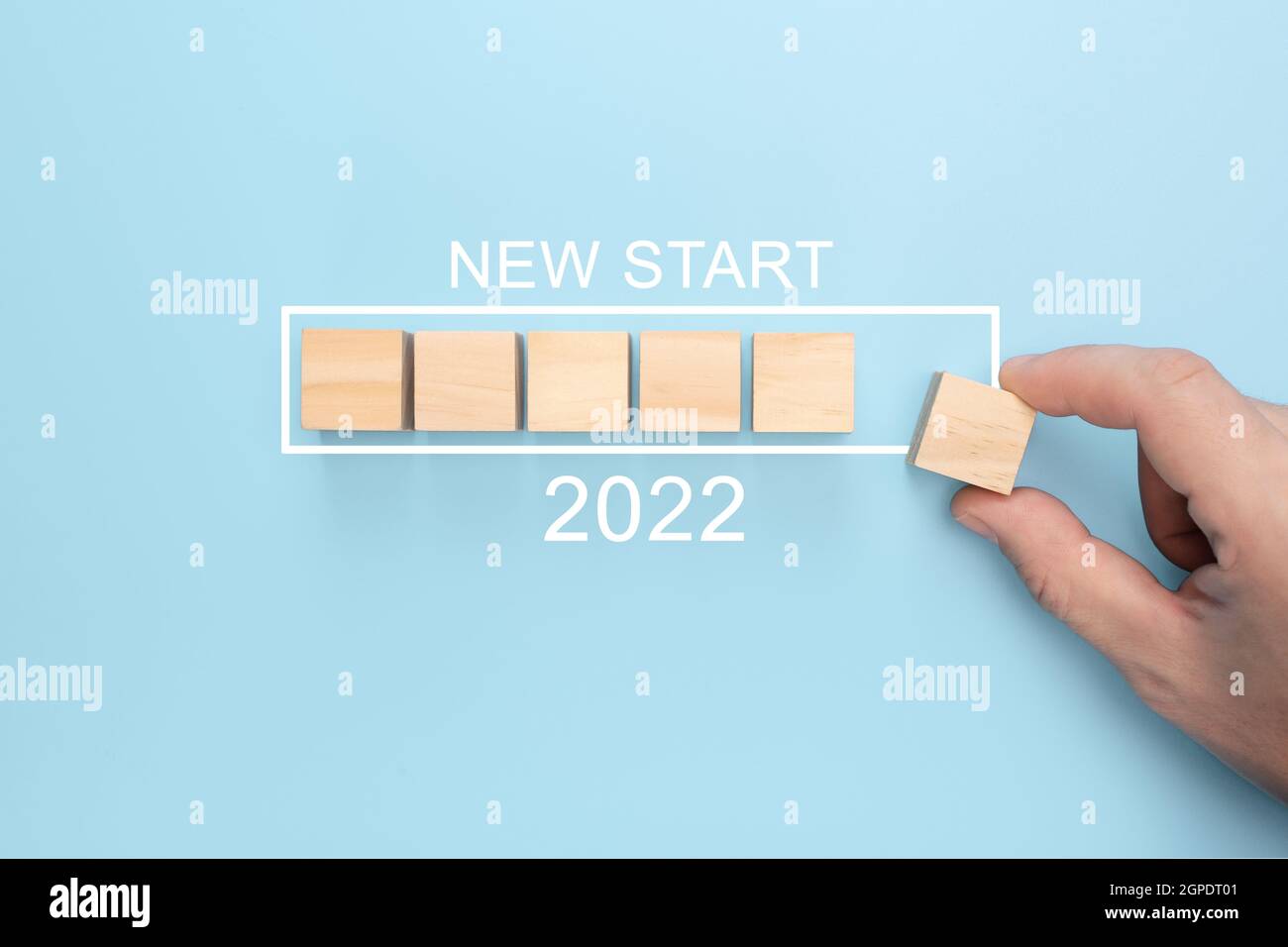 Neues Start 2022 Konzept. Laden des neuen Jahres 2022 mit Hand setzen Holzwürfel in Fortschrittsbalken. Frohes neues Jahr 2022. Konzept starten Stockfoto