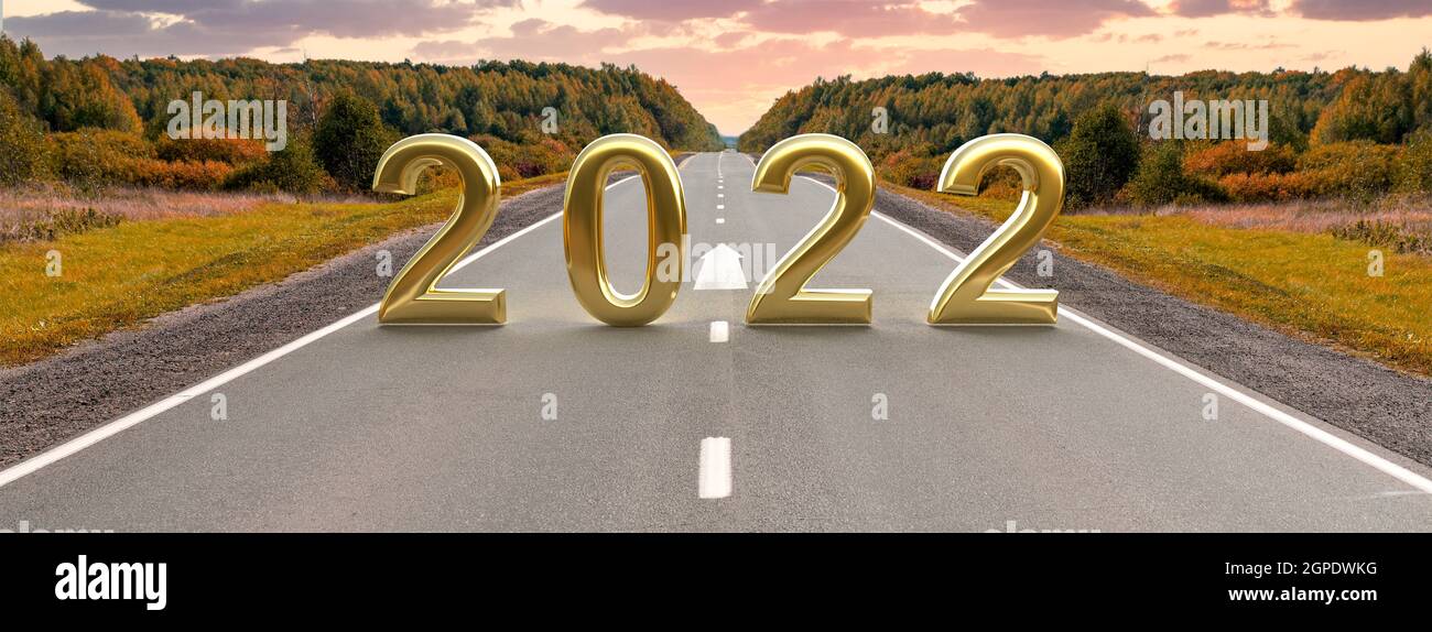 Wort 2022 auf leerer Asphaltstraße bei goldenem Sonnenuntergang und schönem Himmel. Konzept für das Vision-Jahr 2022. Frohes neues Jahr und Weg zum Erfolg Konzept. Fahren Stockfoto
