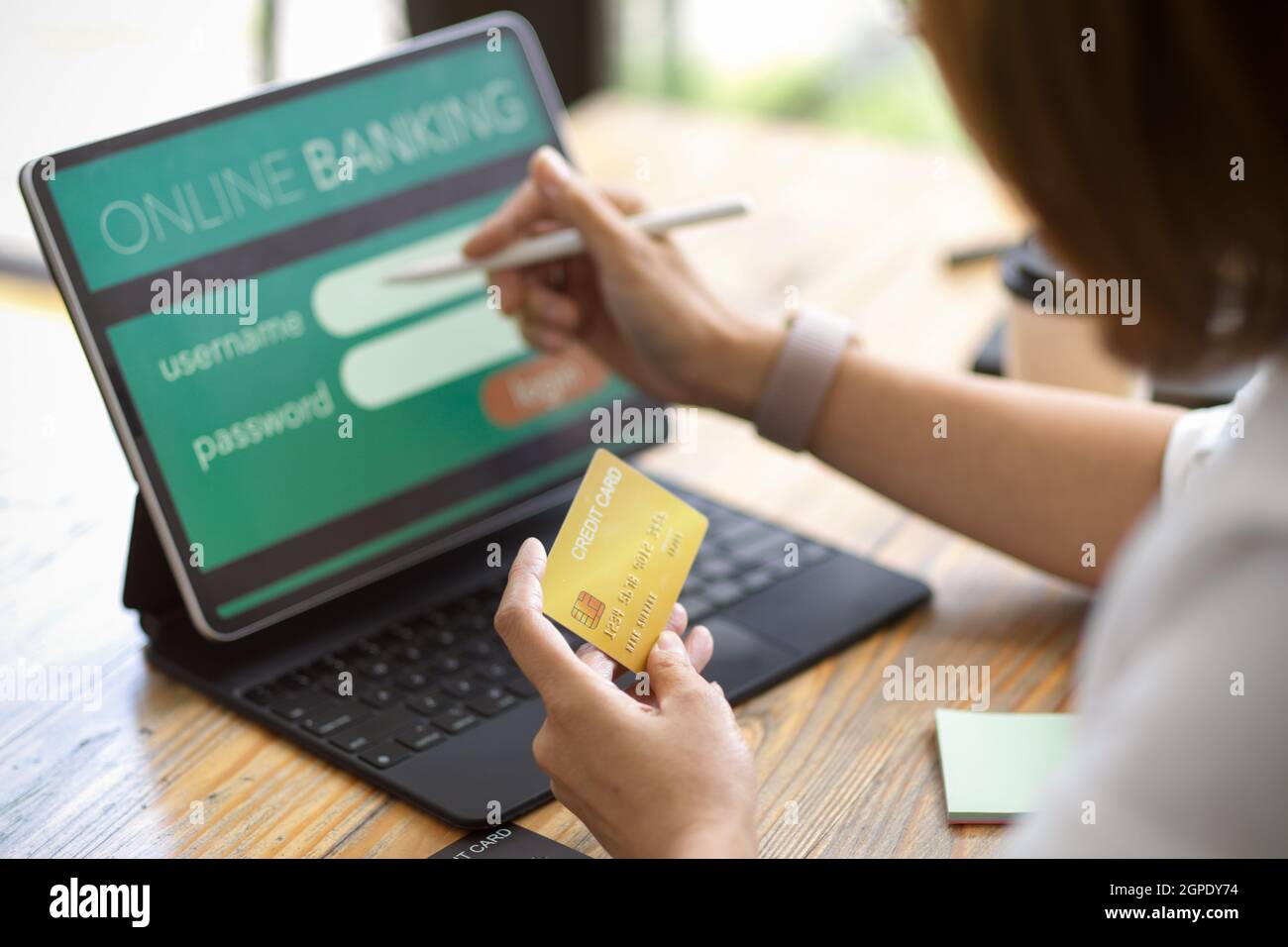 Weiblich, die Online-Banking mit Kreditkarte, Anmeldung, Eingabe von Benutzername und Passwort über digitales Tablet Stockfoto