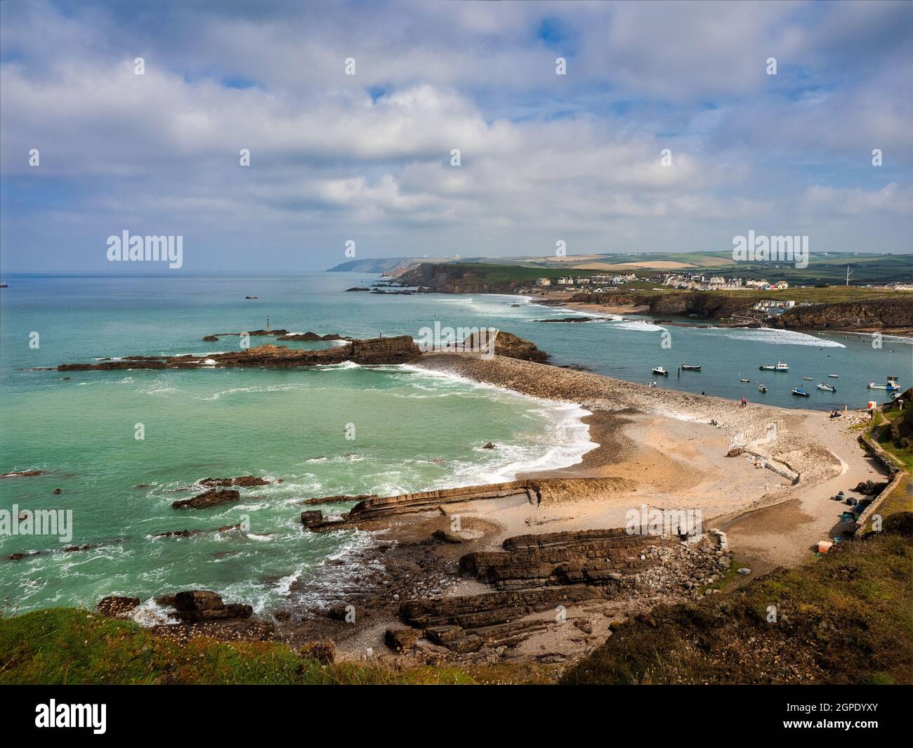 Blick vom Compass Point auf das wunderschöne azurblaue Meer rund um die Bude Breakwater mit dem Hafen und dem Meerpool in der Ferne. Stockfoto