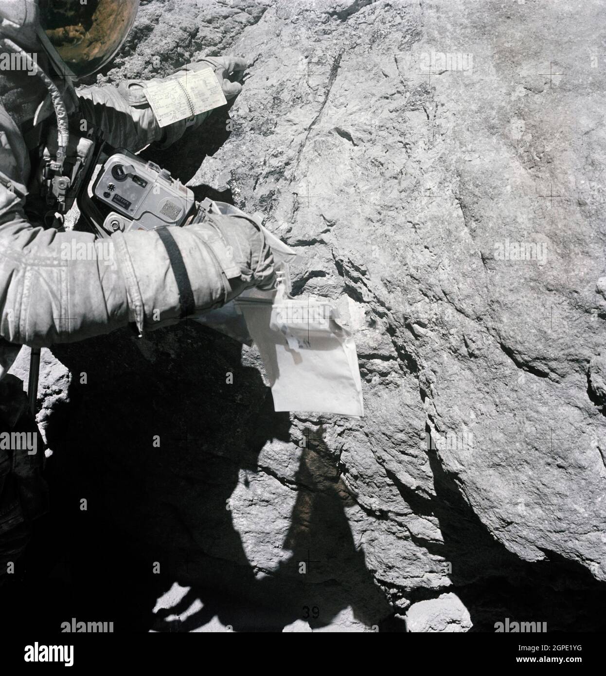 (23. April 1972) --- Astronaut Charles M. Duke Jr., Mondmodulpilot der Apollo 16 Mondlandemission, untersucht während der dritten Apollo 16-Extravehicular-Aktivität (EVA) am Landeplatz Descartes die Oberfläche eines großen Felsens am North Ray Crater genau. Dieses Bild wurde von Astronaut John W. Young, Kommandant, aufgenommen. Beachten Sie die 70-mm-Hasselblad-Kamera auf der Brust. Stockfoto
