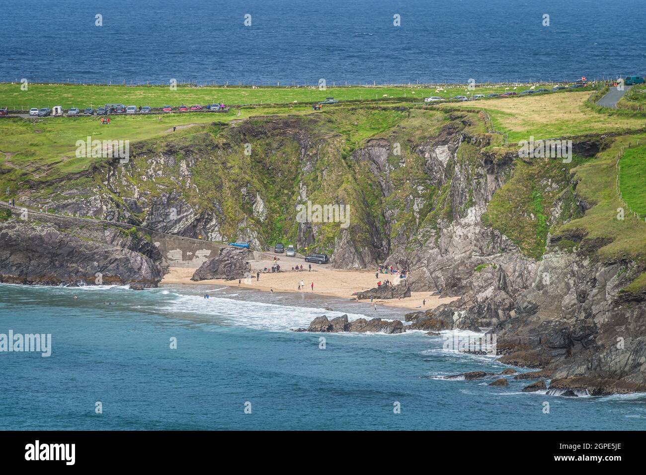 Schwimmen im Meer und Entspannen am kleinen versteckten Coumeenoole Beach zwischen Klippen auf der Halbinsel Dingle, Wild Atlantic Way, Kerry, Irland Stockfoto