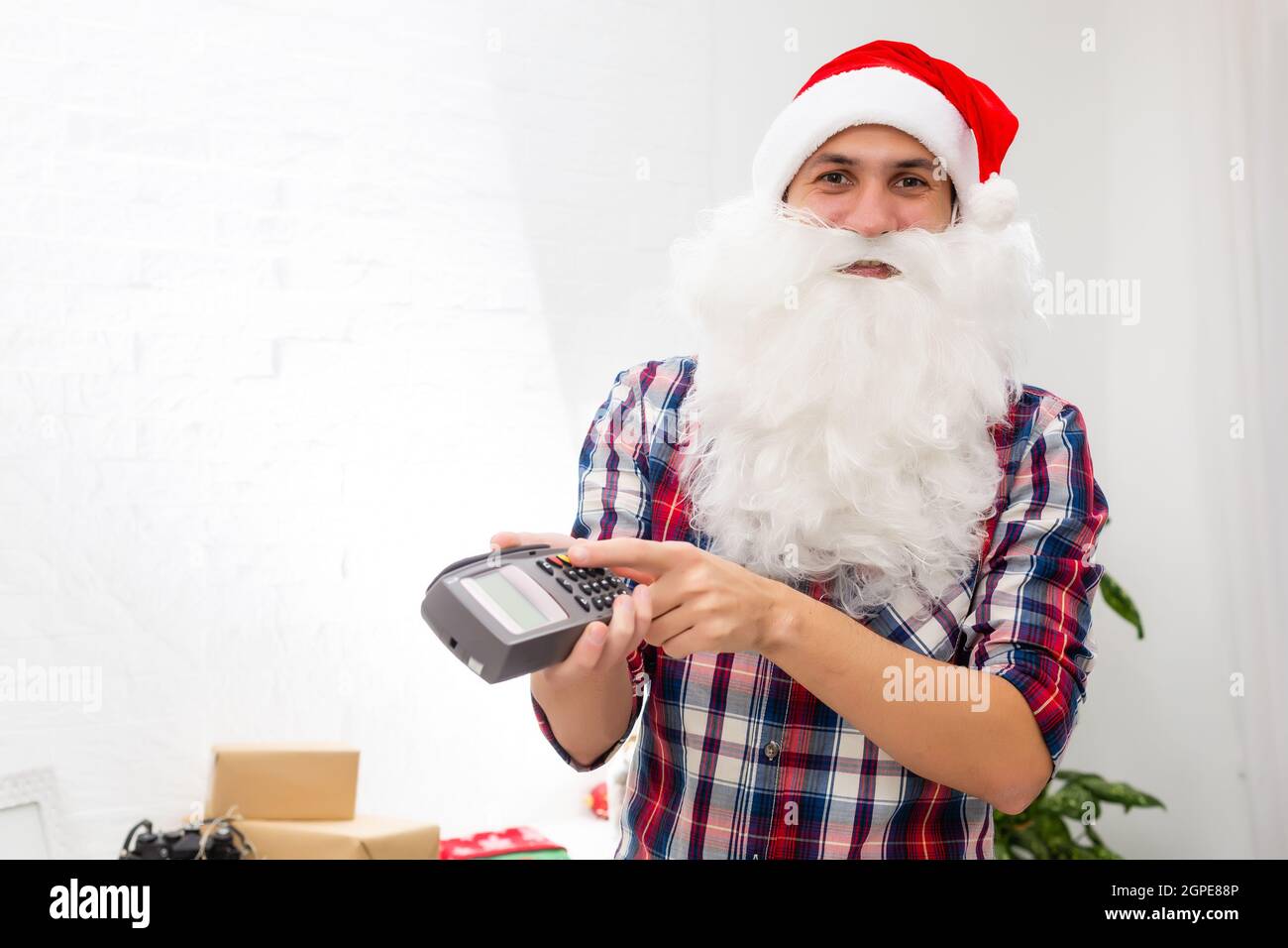 Porträt von seinem er schöne attraktive Santa halten in der Hand bankkarte digitales Terminal System Handel Handel Stockfoto