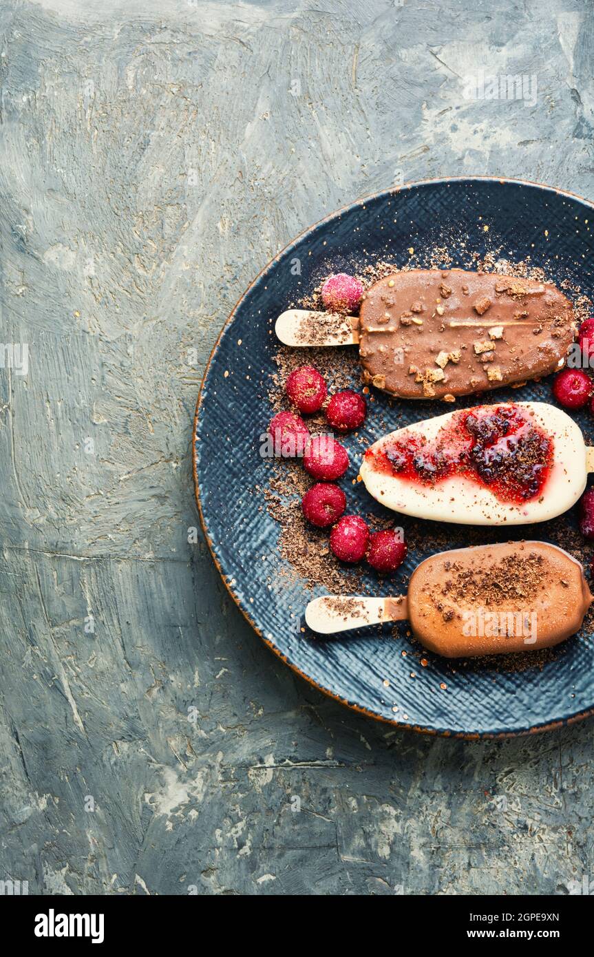 Eis auf Stöcken mit Schokolade.Schokoladenüberzogene Eis mit Kirschmarmelade Stockfoto