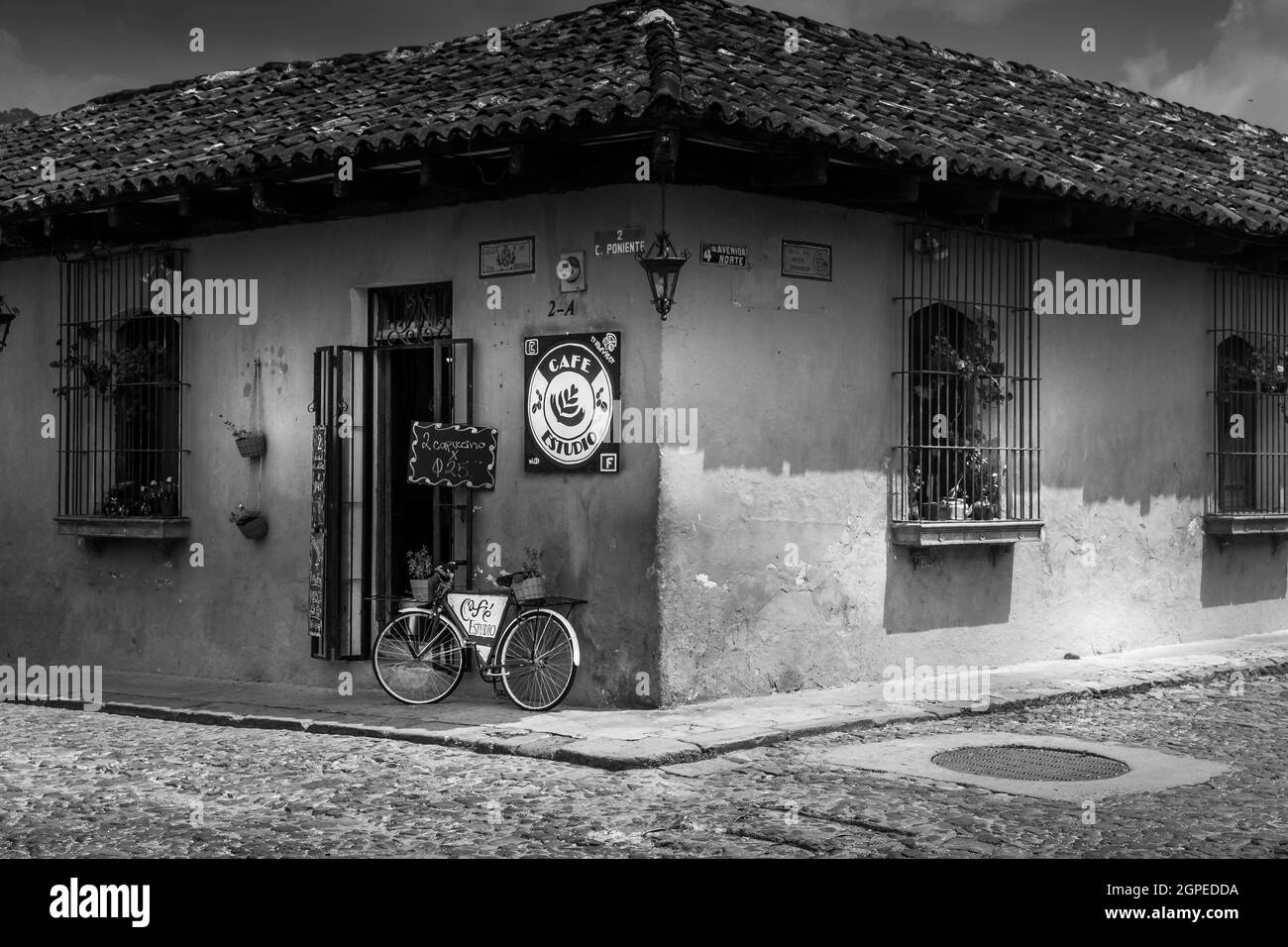 Schwarz-Weiß-Bild eines Eck-Shops mit einarmem Fahrrad an der Wand in Cartagena, Kolumbien, Südamerika. Keine Personen. Stockfoto