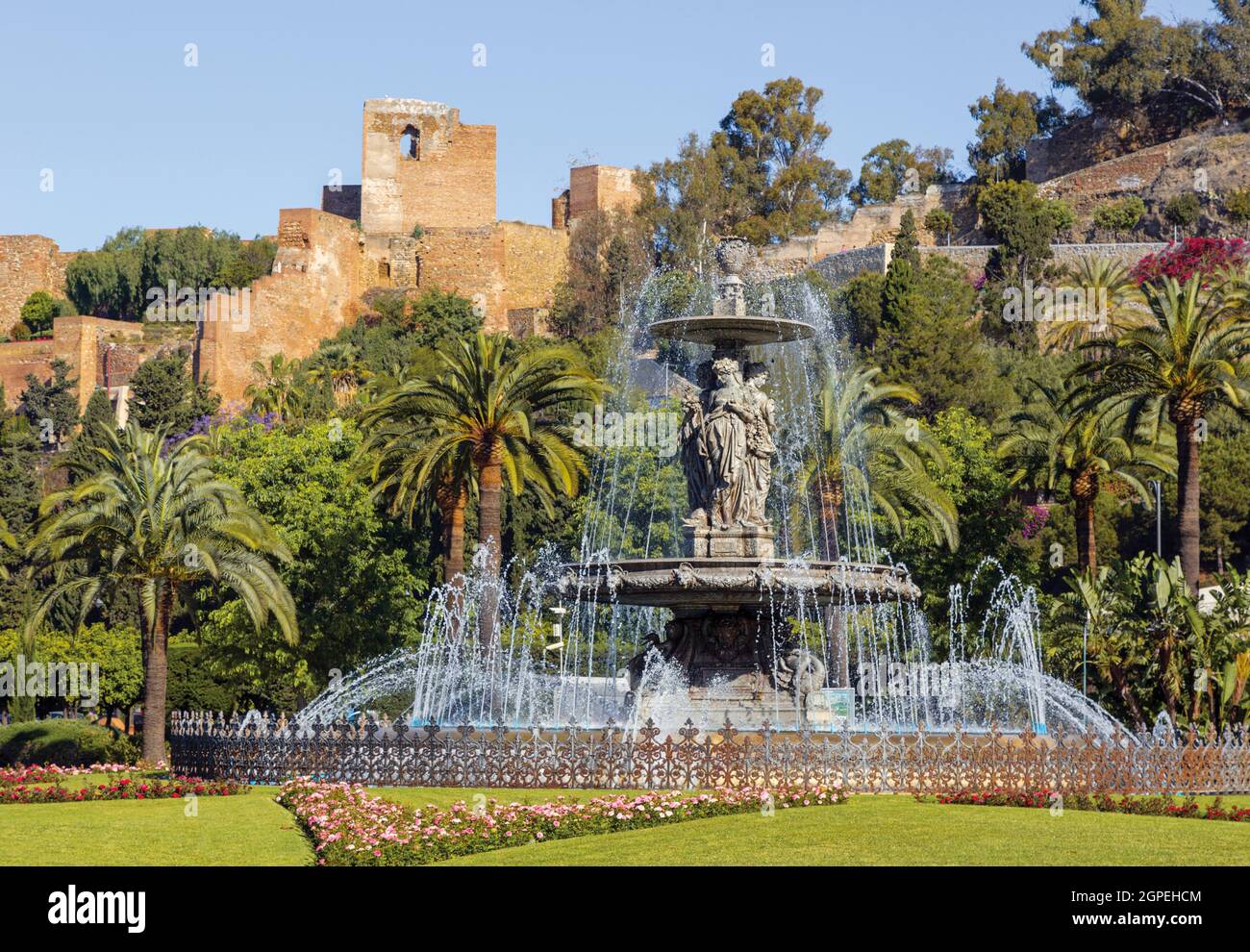 Brunnen der drei Grazien auch bekannt als die drei Nymphen auf der Plaza del General Torrijos mit der maurischen Alcazaba oder Festung dahinter. Malaga, Cos Stockfoto