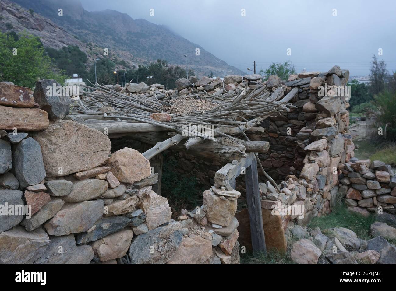 Überreste eines alten Hauses in der südlichen Region Saudi-Arabiens. Das Haus ist aus Felsen und Schlamm gebaut und die Decke ist aus Holz und mit Schlamm bedeckt. Stockfoto