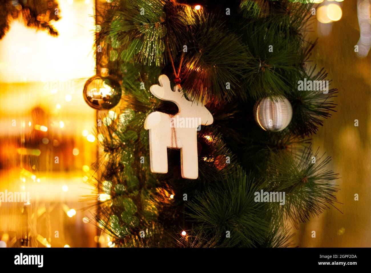 Weihnachtskarte mit Weihnachten Spielzeug, Tannenzweigen und girlande Bokeh. Einrichtung von tannenzweigen und des Neuen Jahres Einrichtung mit traditionellen Holzmöbeln Rotwild, klicken Sie Stockfoto